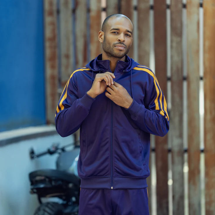 a man wearing a Montique's purple tracksuit with yellow stripes.