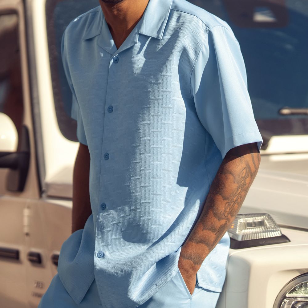 Front view of the sky blue short sleeve men's walking suit shirt and matching pants on model.