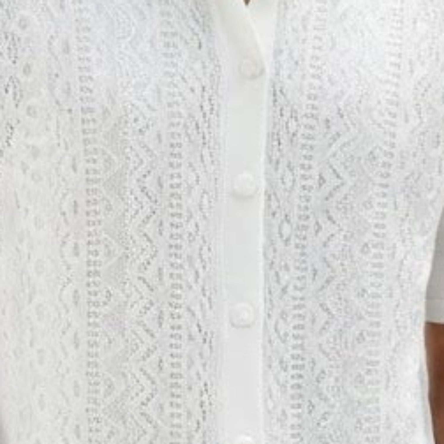 Close-up of white walking suit shirt showing the intricate vertical knit texture and button details.
