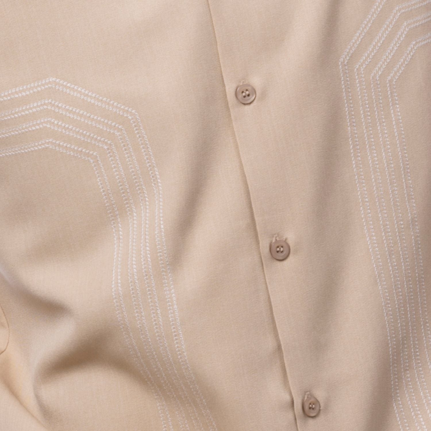 Close up of the beige walking suit with geometric embroidery panel shirt and solid pants