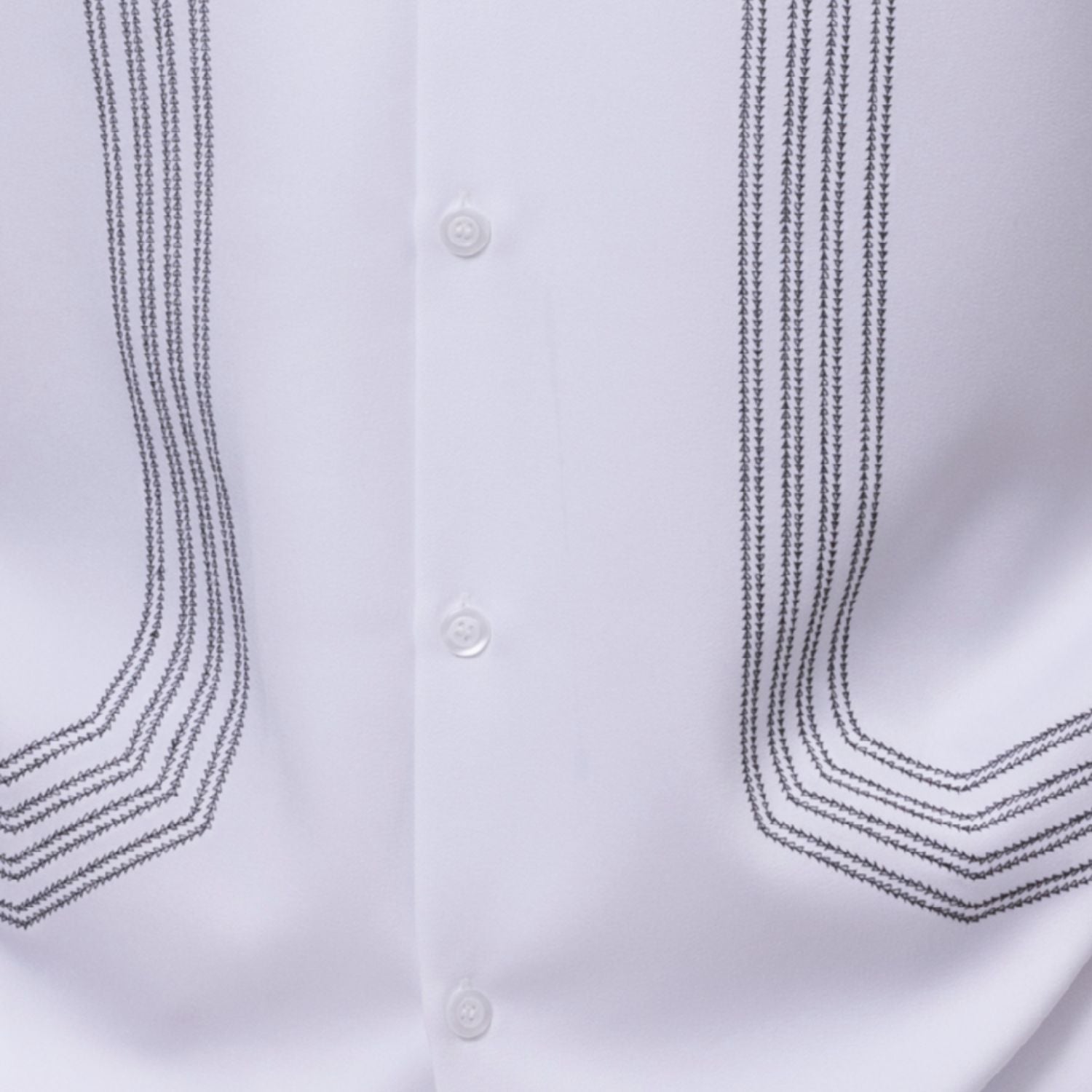 Close up of the white walking suit with geometric embroidery panel shirt and solid pants