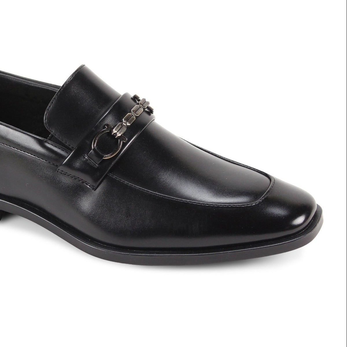 Close-up three-quarter view of men’s black moc-toe loafer with metallic bit hardware