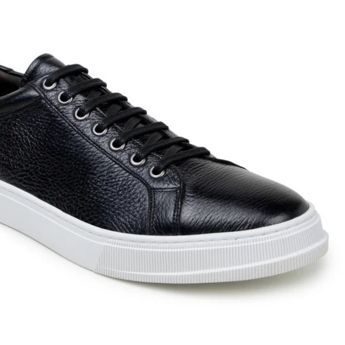 Side view of black deerskin sneaker with white sole