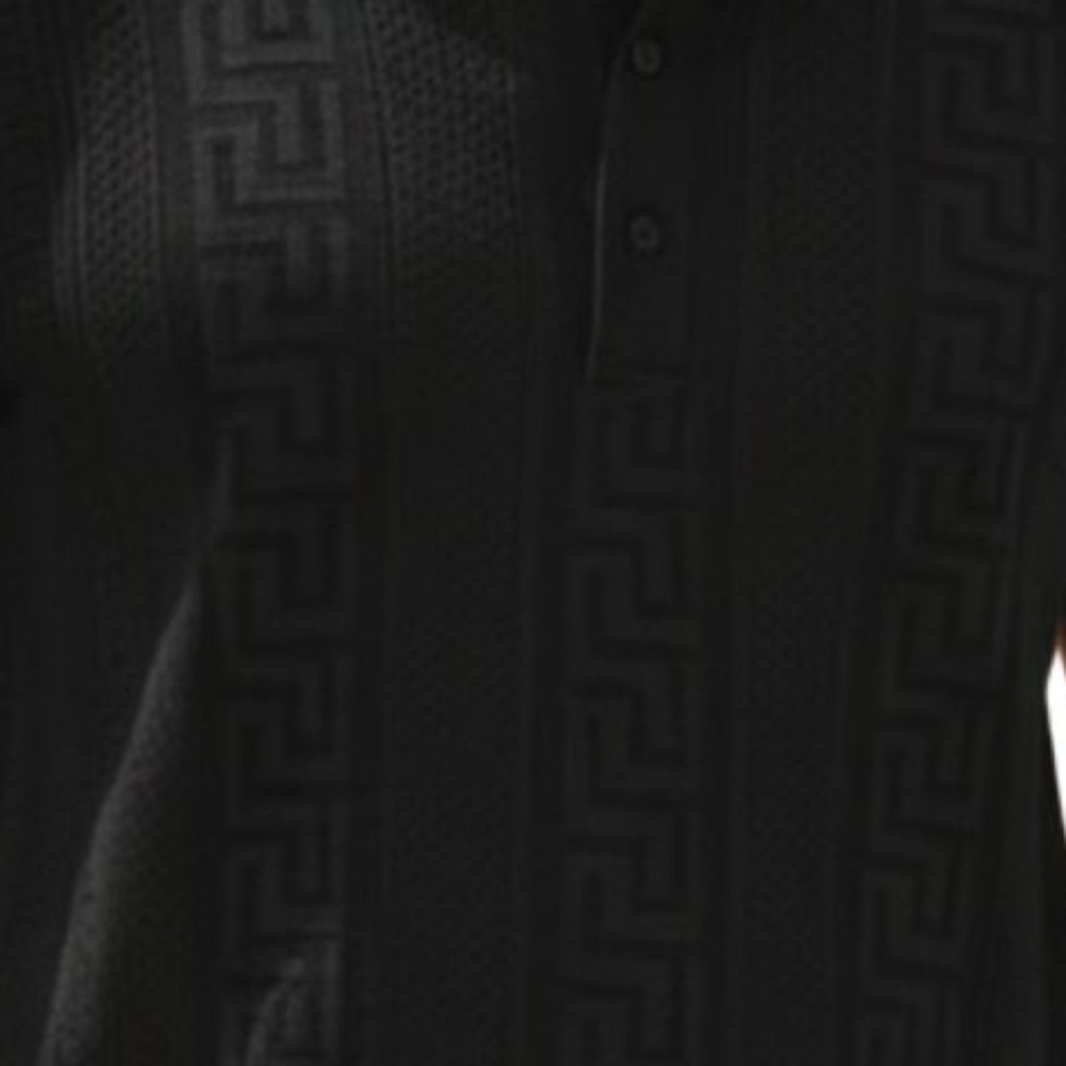 Black textured knit polo shirt detail showing the structured collar and three-button placket.