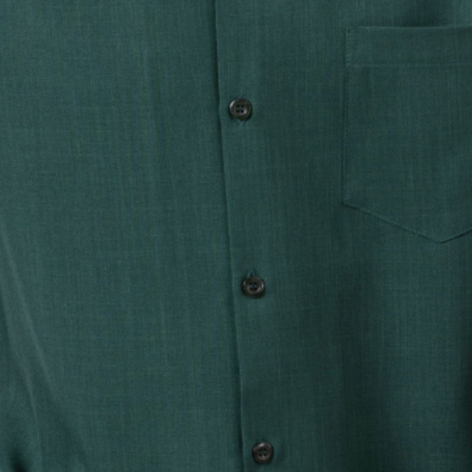 Close-up of emerald green 100% polyester fabric showing the solid texture and button detail