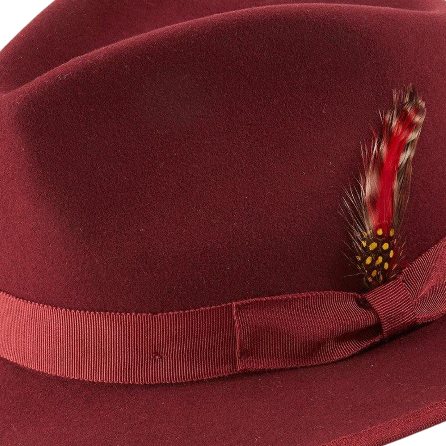 side view of burgundy wool felt hat with feather accent