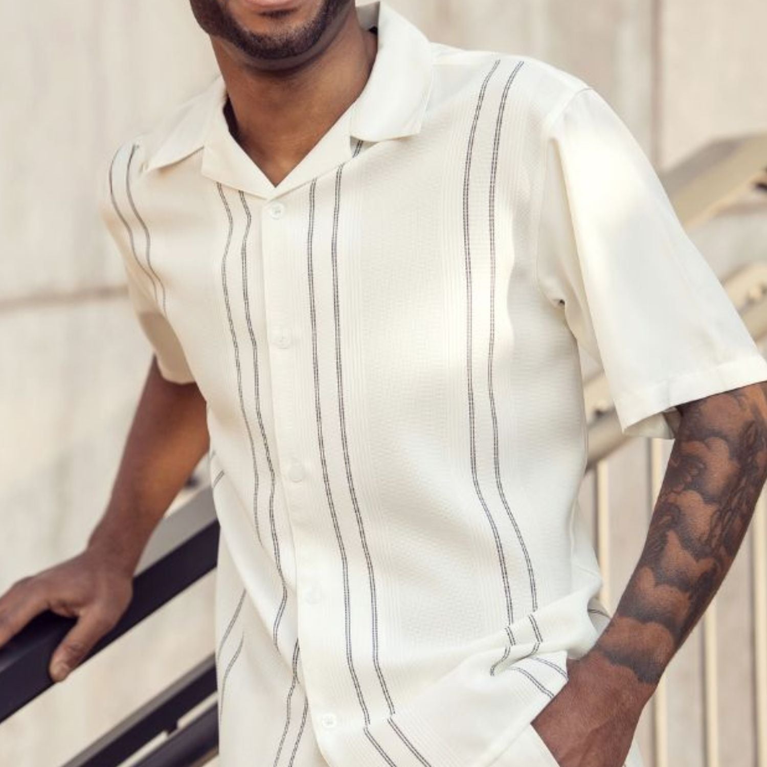 Close-up of cream men's walking suit shirt showing the textured vertical line panel design and collar.