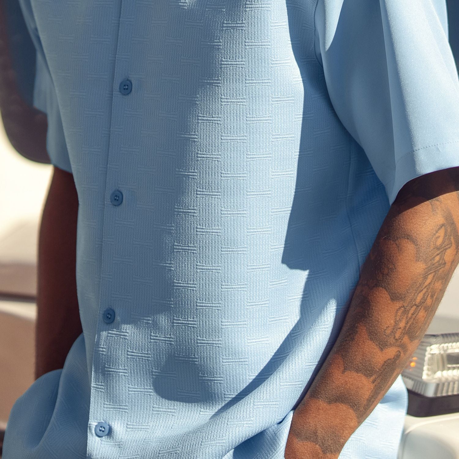 Close-up of sky blue men's walking suit shirt showing the detailed tonal geometric woven texture.