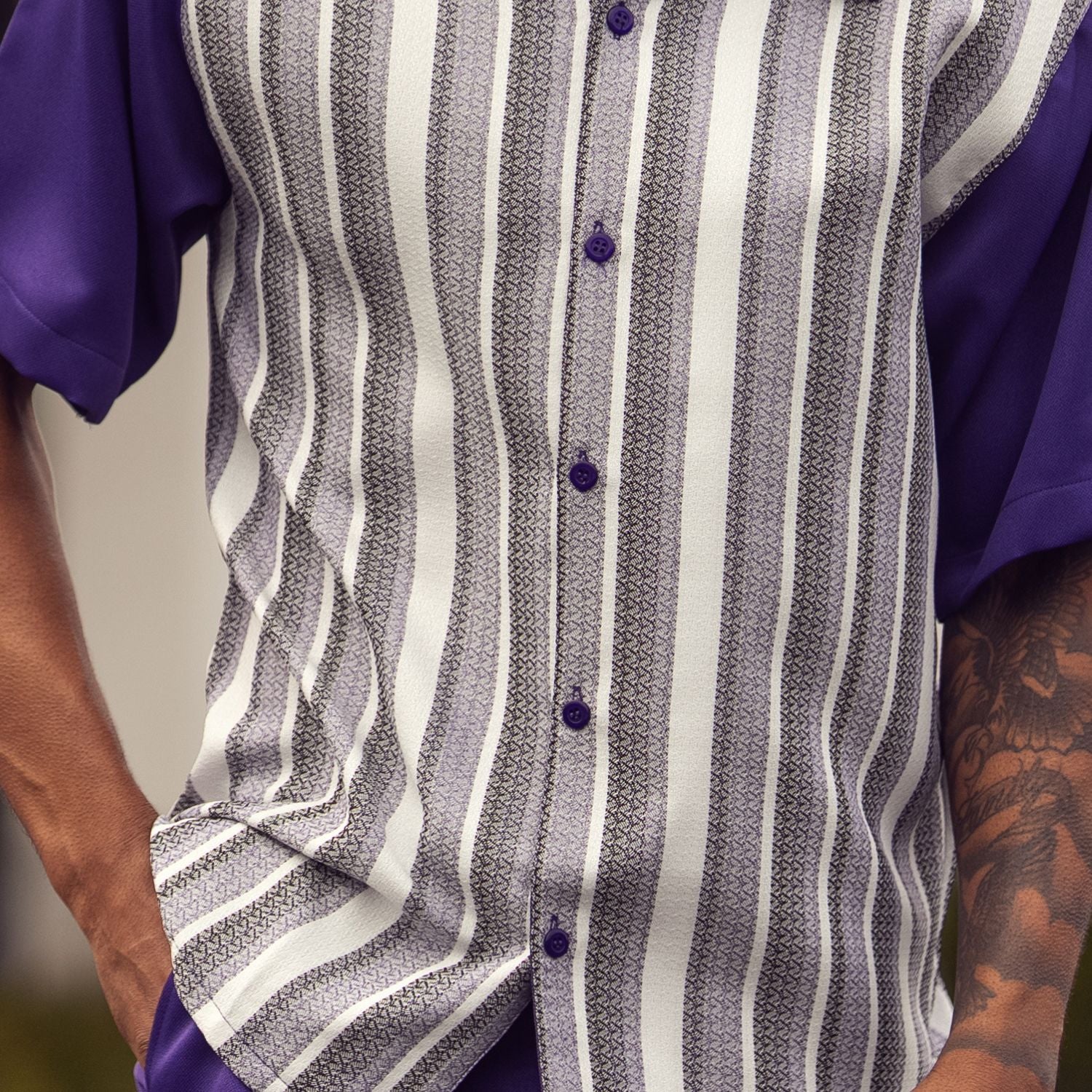 Close-up of purple walking suit shirt showing the detailed vertical striped pattern in white and grey.