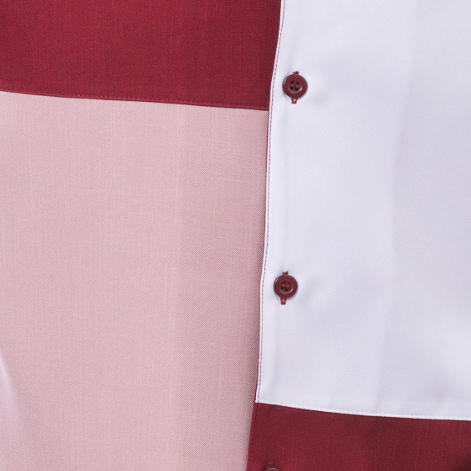 Close-up of ruby and blush walking suit shirt showing the clean color block panels and coordinated tonal buttons.
