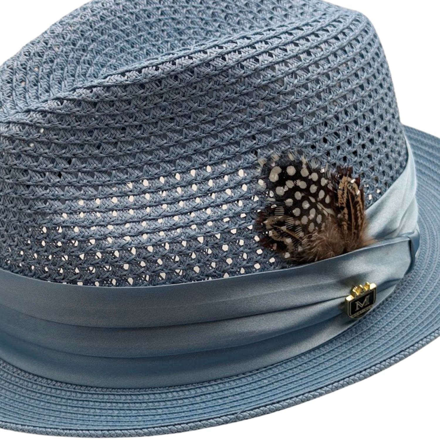 close up of Montique Carolina vented straw fedora hat with feather, ribbon band, and logo pin