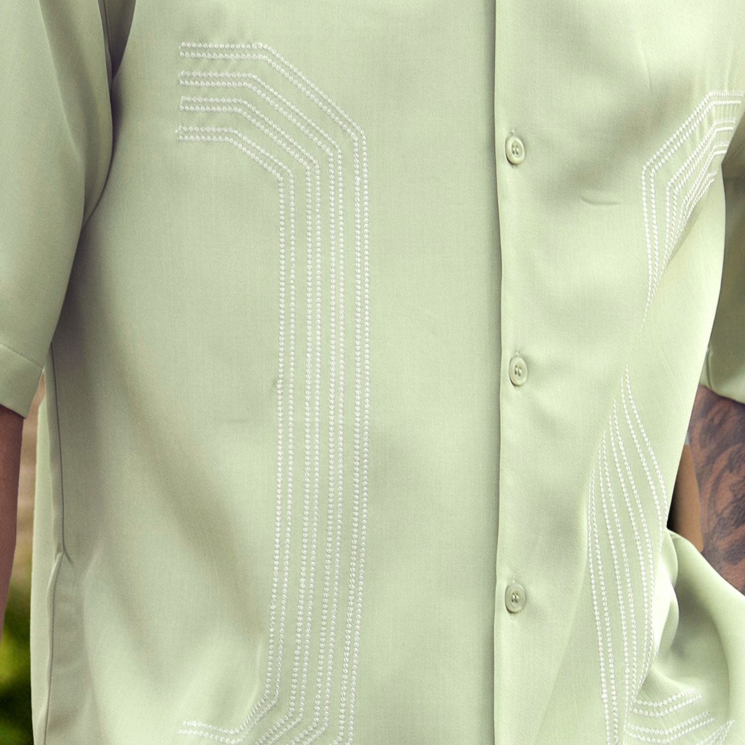 Close up of embroidered panel detail on mint walking suit shirt