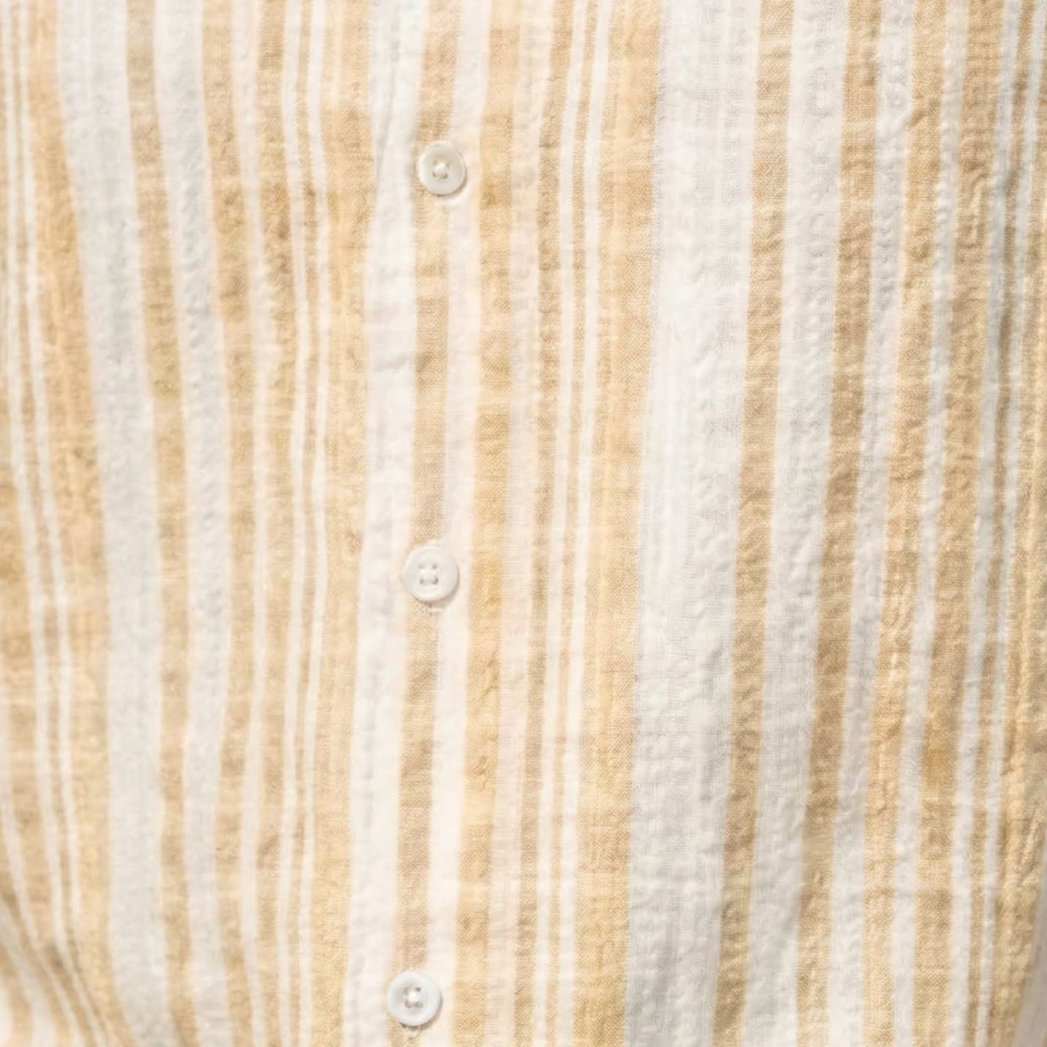 Close-up fabric of tan striped seersucker short sleeve shirt