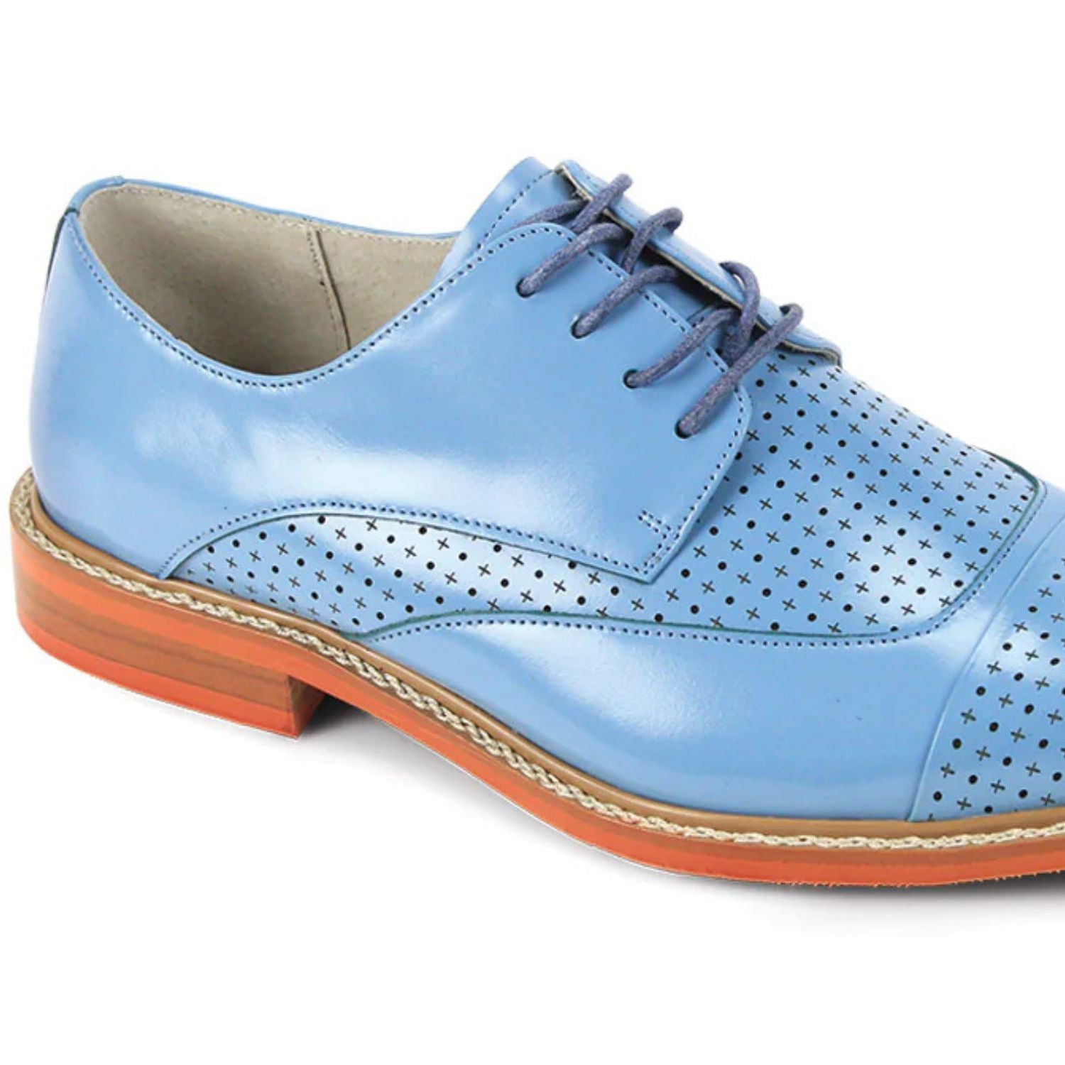 Close-up of intricate laser perforated pattern and brogue detailing on light blue leather shoe.