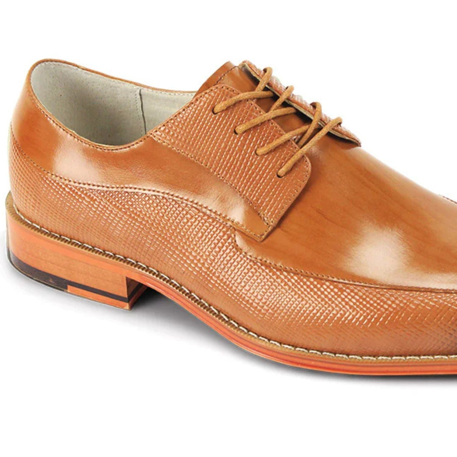 Close-up of tan embossed leather texture and moc toe stitching detail.