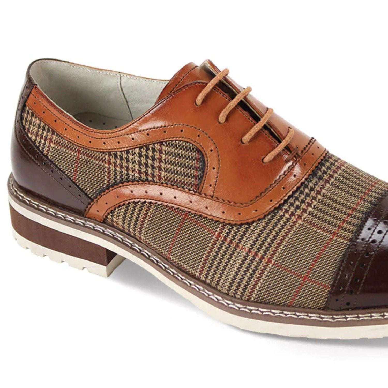 Close-up of dark brown leather brogue detail and whiskey-colored patterned tweed texture.