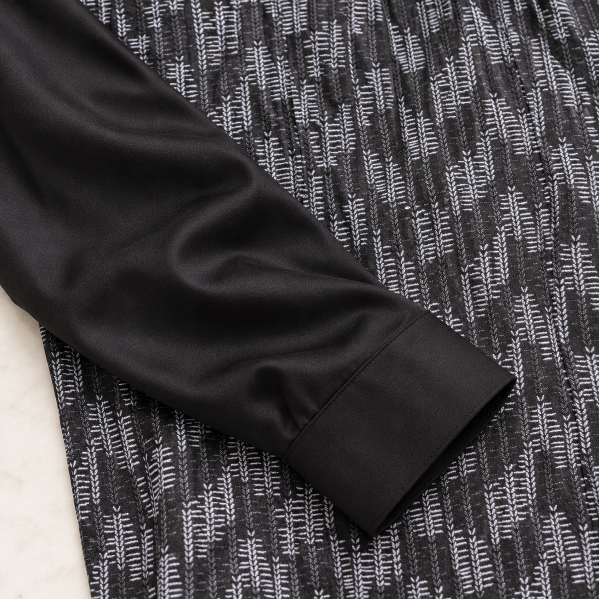 Smooth black sleeve and cuff contrasting with the fine white dash pattern on a Montique walking suit shirt.