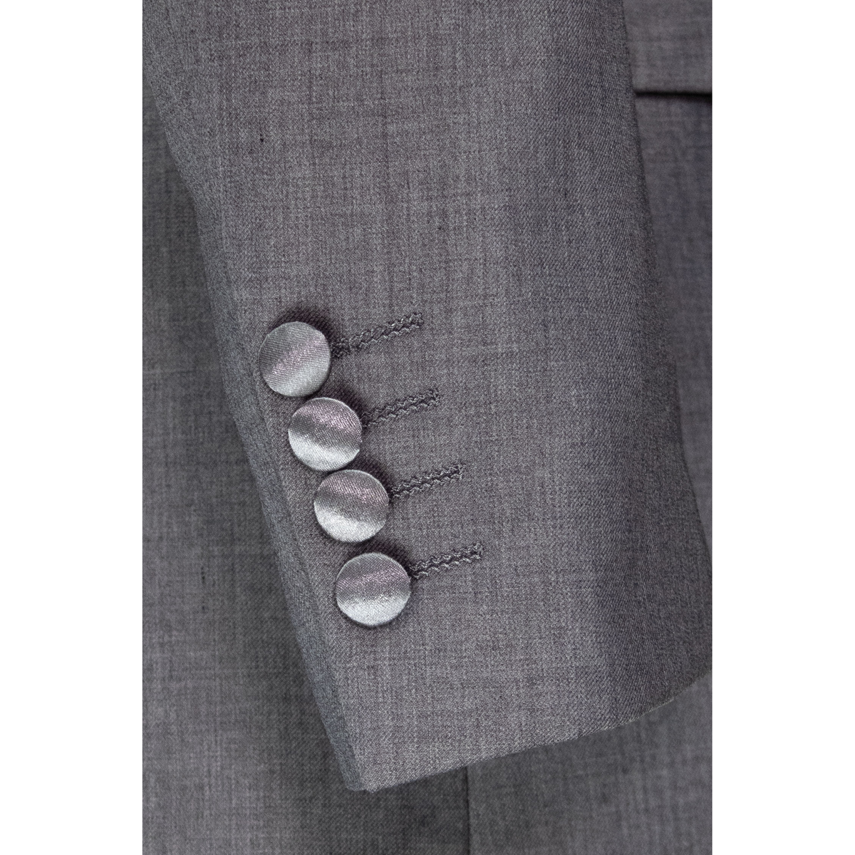 Close-up of the light grey jacket sleeve, showing four satin-covered cuff buttons and woven fabric.