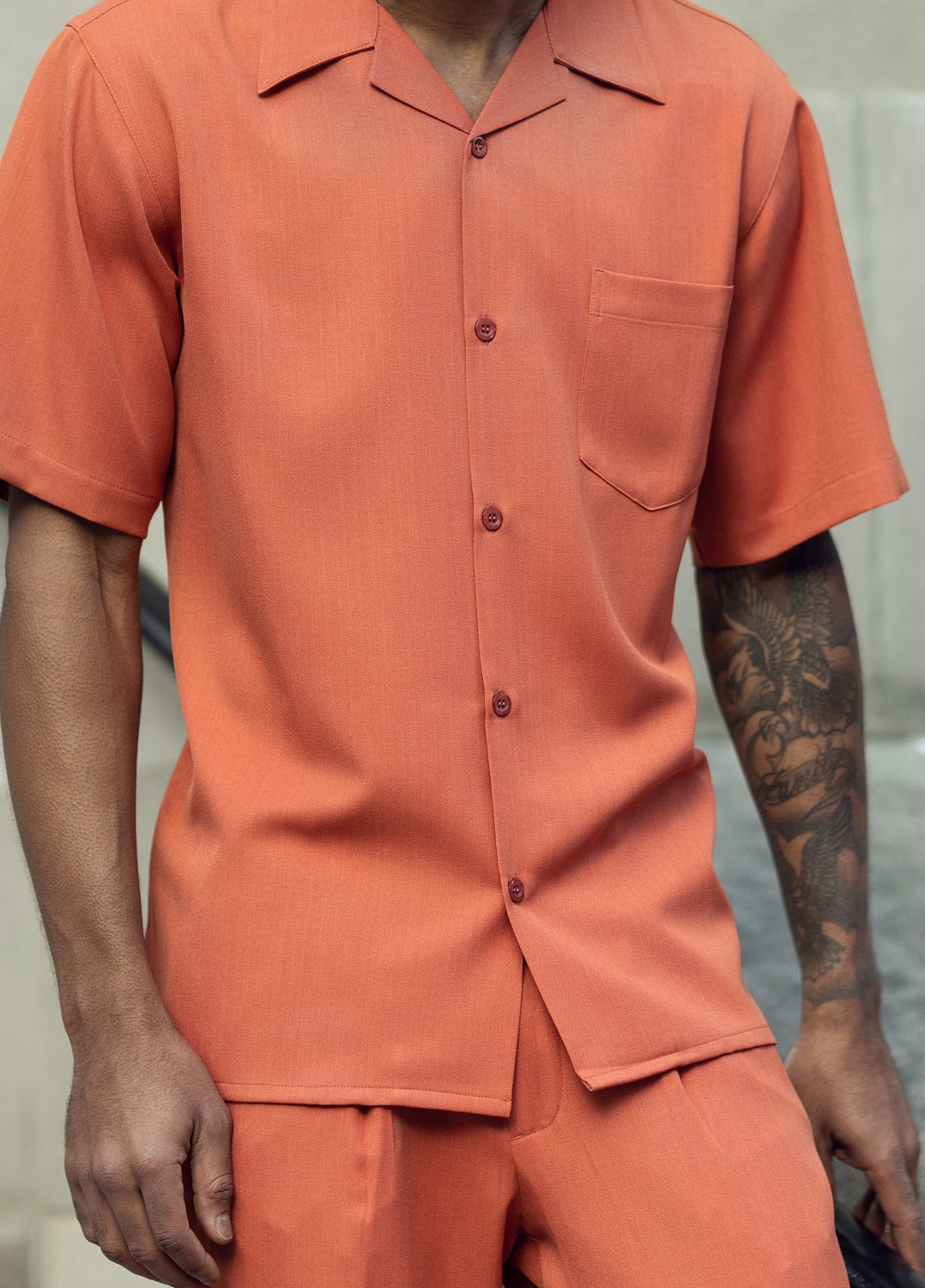 Close-up of papaya 100% polyester fabric showing the solid texture and button detail