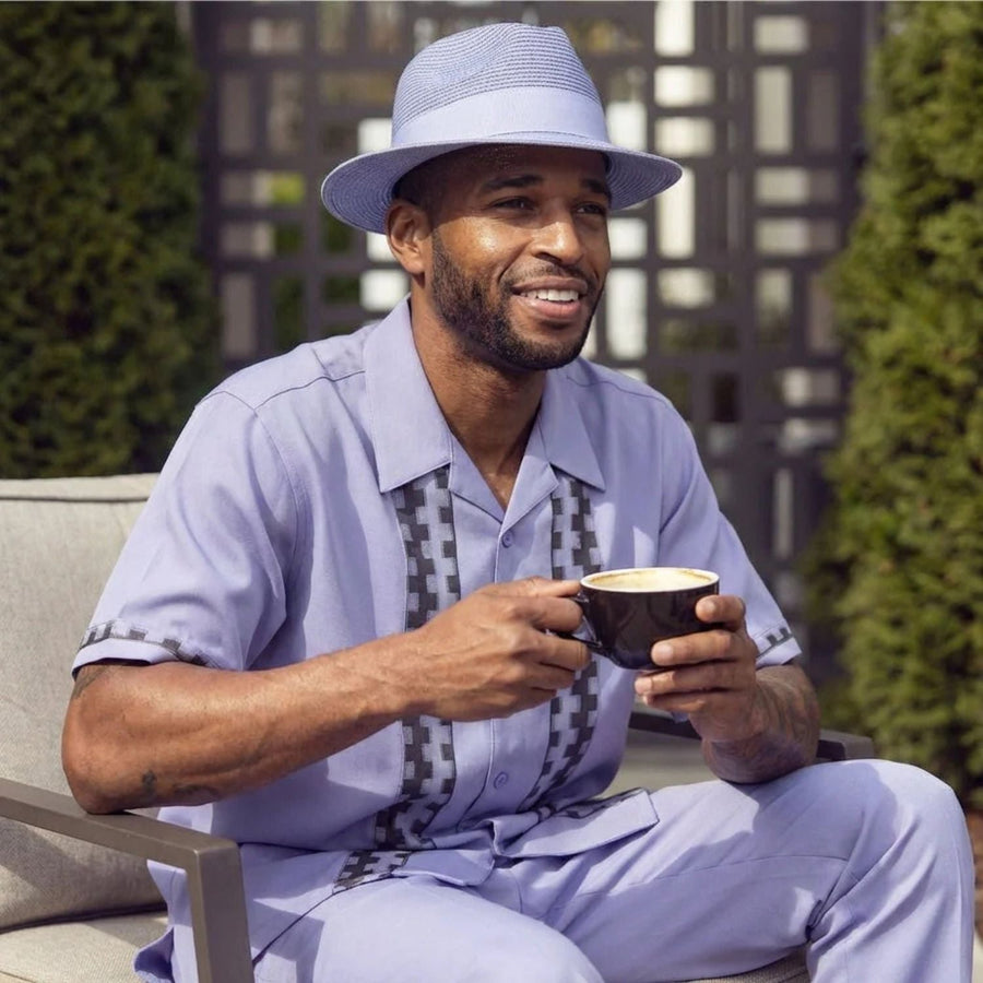 man wearing lavender walking suit holding a cup of coffee