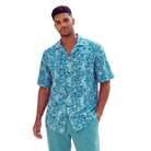 Teal men's short-sleeve shirt with a multi-colored abstract print and open camp collar.