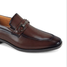Close-up three-quarter view of men’s brown moc-toe loafer with metallic bit hardware