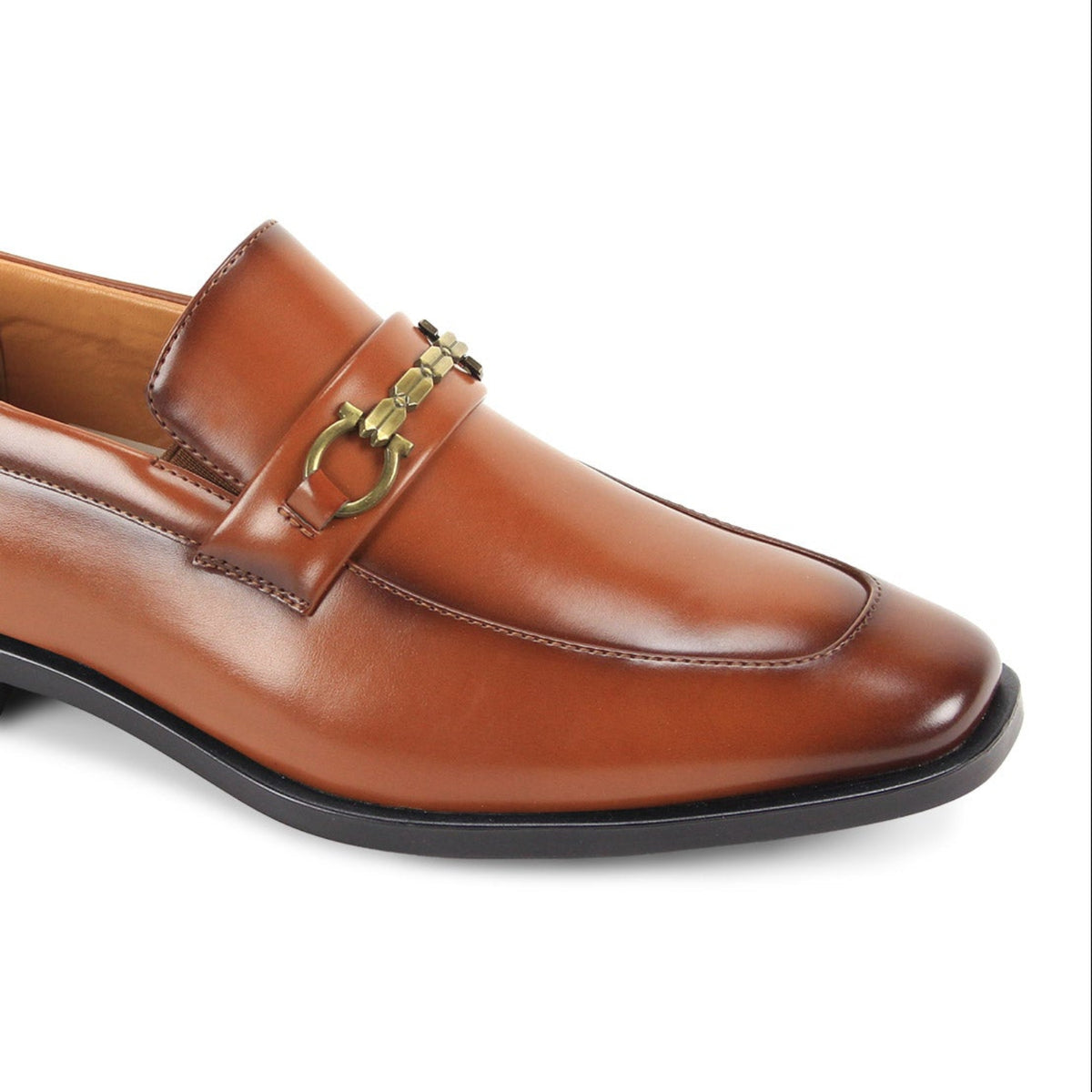 Close-up three-quarter view of men’s cognac moc-toe loafer with metallic bit hardware