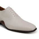 Angled view of light bone leather Oxford dress shoe