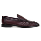Side view of burgundy Italian deerskin penny loafer