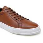 Side view of antique tan deerskin sneaker with white sole