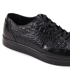 Close-up of black croc-embossed leather texture and smooth leather paneling.