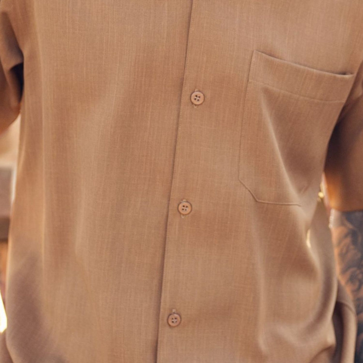 Close-up of cappuccino 100% polyester fabric showing the solid texture and button detail