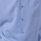 Close-up of carolina blue 100% polyester fabric showing the solid texture and button detail