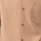 Close-up of tan 100% polyester fabric showing the solid texture and button detail