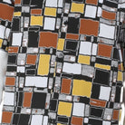 Close up of mosaic square pattern shirt in black, mustard, orange, and white