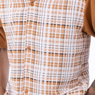 Close up of the men's cognac plaid short sleeve walking suit with matching cuffed shorts