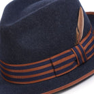 montique navy fedora with tan trim and striped ribbon side view