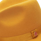 side view gold felt hat with red underside