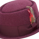 side view burgundy pork pie hat with feather and ribbon band