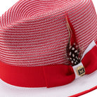 Side detail of red and white Montique fedora hat with grosgrain ribbon and feather