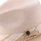 Side view of beige fedora hat with striped ribbon band and pin