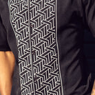 Black polyester men's walking suit shirt front close-up showing tonal geometric block panel puff detail.