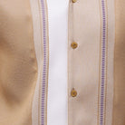 Close-up of beige walking suit shirt showing the white woven color-block panel and detailed stitched tracks.