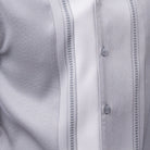 Close-up of grey walking suit shirt showing the white woven color-block panel and detailed stitched tracks.