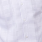 Close-up of white walking suit shirt showing the detailed textured tone-on-tone weave pattern.
