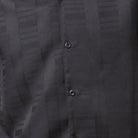 Close-up of black men's walking suit shirt showing the subtle tone-on-tone textured weave pattern.