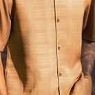 Close-up of camel men's walking suit shirt showing the subtle tone-on-tone textured weave pattern.