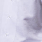 Close-up of white men's walking suit shirt showing the detailed tonal geometric woven texture.