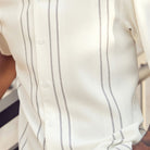 Close-up of cream walking suit shirt showing the detailed textured micro-grid and vertical line paneling.