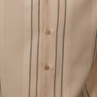 Close-up of beige walking suit shirt showing the detailed textured micro-grid and vertical line paneling.